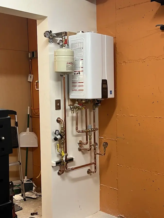 Plumbing technician inspecting water heater connections in Bellmead
